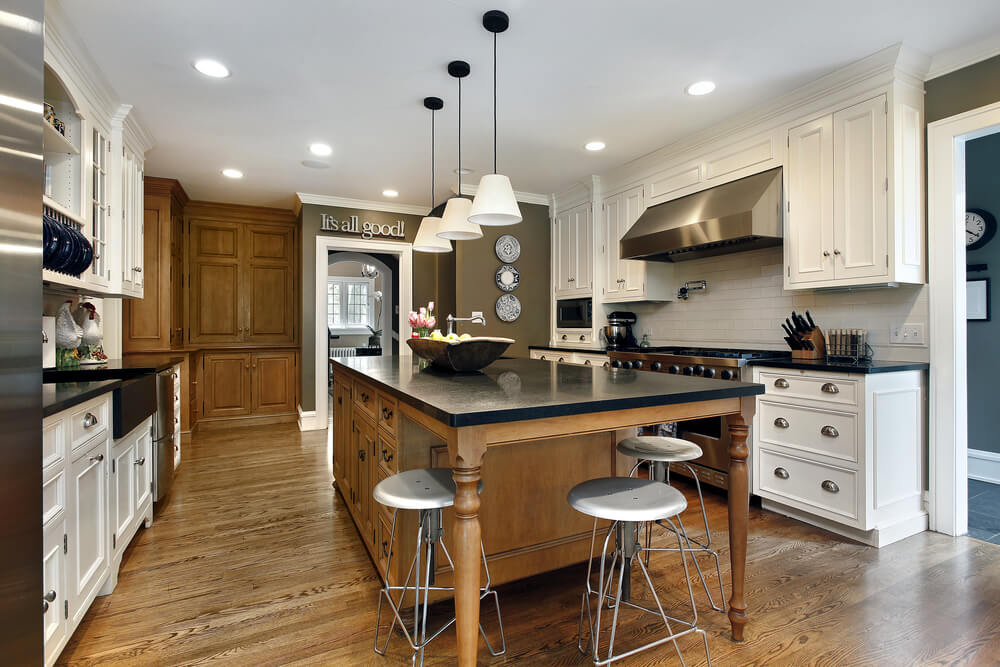 This brown wooden island helps the existing tall cabinets of the same 